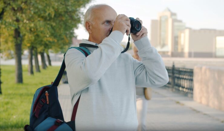 an elderly gentleman holding his camera, ready to capture the moment
